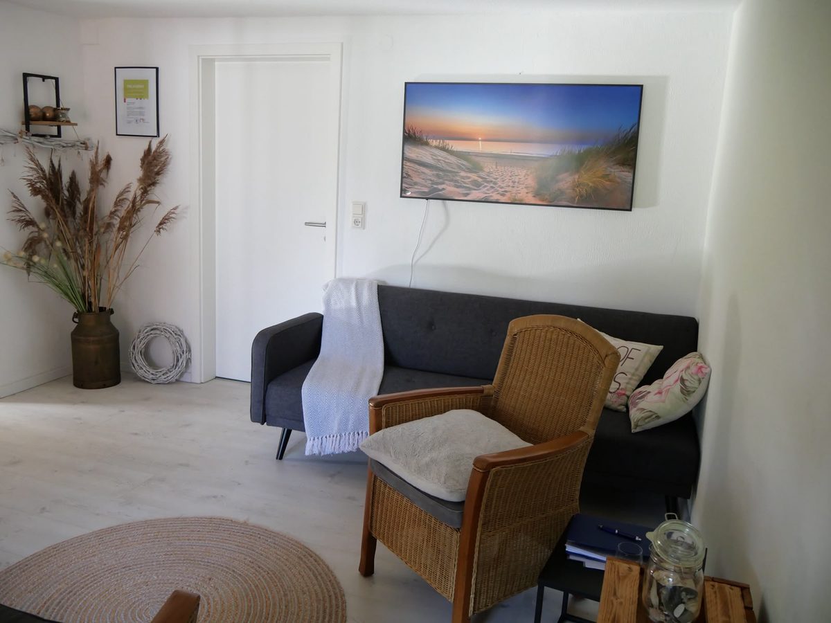 Praxisraum mit Sofa und Korbsessel